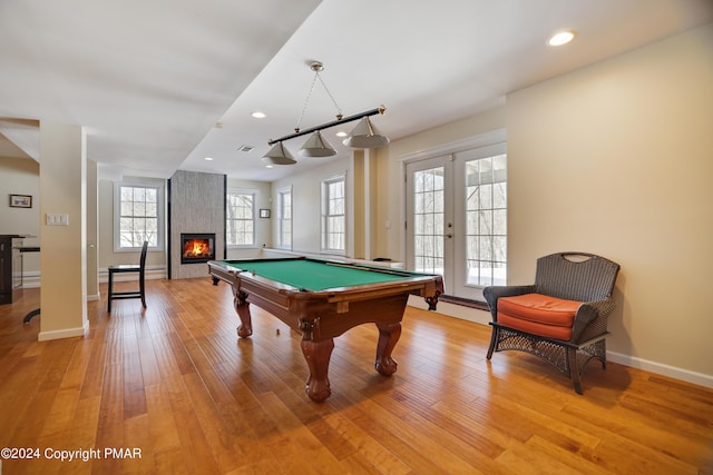 recreation room featuring french doors, a fireplace, recessed lighting, light wood-type flooring, and baseboards