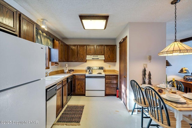 kitchen with a textured ceiling, under cabinet range hood, white appliances, a sink, and light countertops