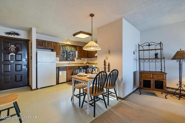 dining room with a textured ceiling and baseboards