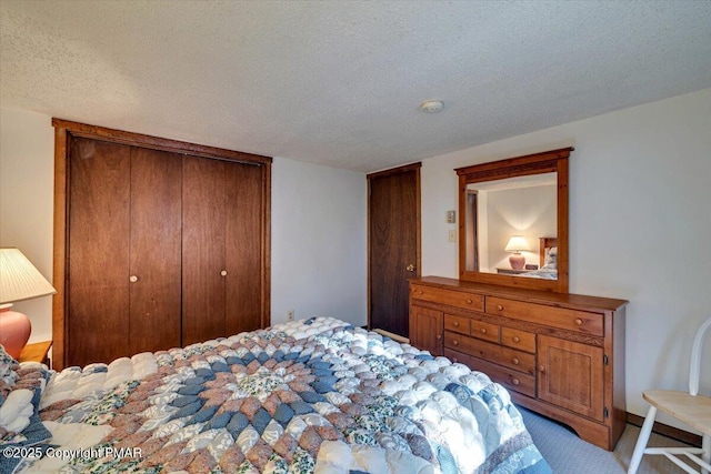 bedroom featuring a closet, light carpet, and a textured ceiling