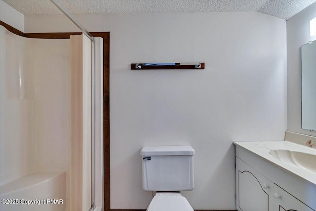 bathroom with toilet, a shower stall, a textured ceiling, and vanity