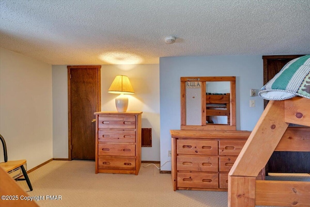 bedroom featuring a textured ceiling, baseboards, and light colored carpet