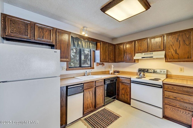 kitchen with white appliances, light countertops, a sink, and under cabinet range hood