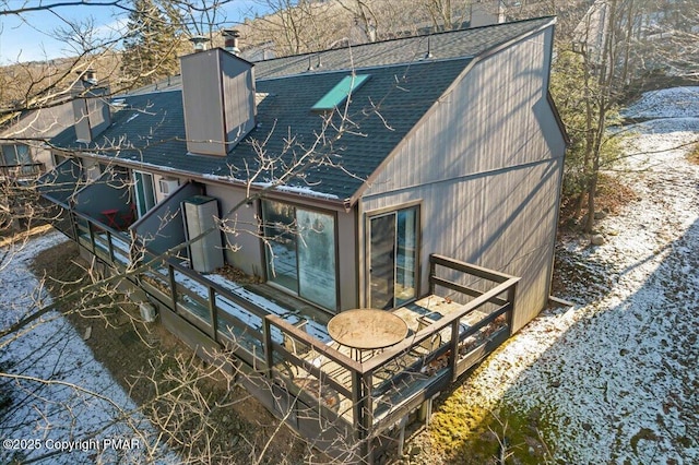 back of house with a shingled roof