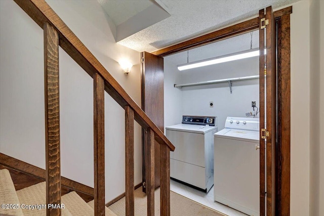 washroom featuring laundry area, a textured ceiling, and washing machine and clothes dryer