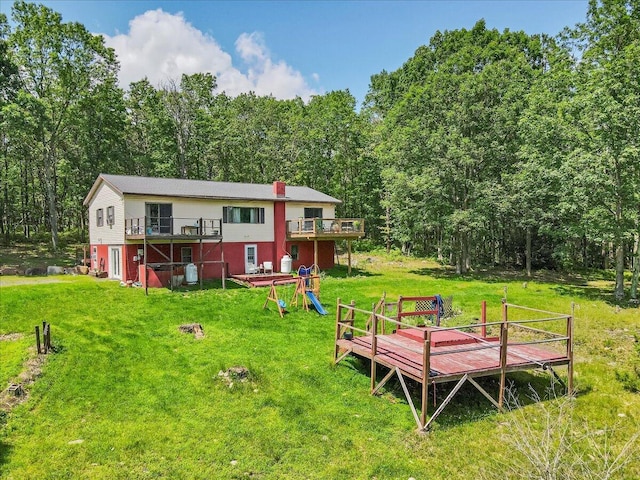 446 Dew Drop Dr, Jim Thorpe, PA 18229 - back of property with a deck, a lawn, a wooded view, and a chimney