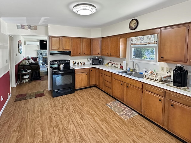 7537 Lake Shore Dr, Pocono Lake, PA 18347 - kitchen with black appliances, a wall mounted air conditioner, light wood-style flooring, light countertops, and brown cabinets