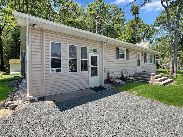 7537 Lake Shore Dr, Pocono Lake, PA 18347 - rear view of house with a chimney and a lawn