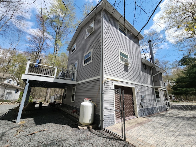 419 Quaker Ct, Pocono Lake, PA 18347 - view of side of home with an attached garage, driveway, a deck, and fence