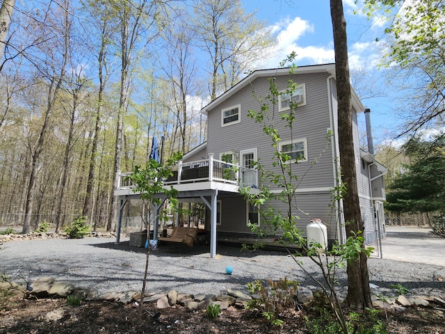 419 Quaker Ct, Pocono Lake, PA 18347 - rear view of property featuring a wooden deck, driveway, and fence