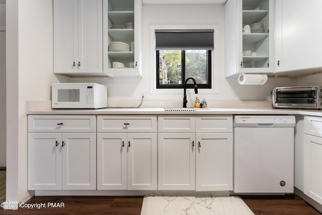 kitchen with a toaster, white appliances, a sink, white cabinetry, and light countertops