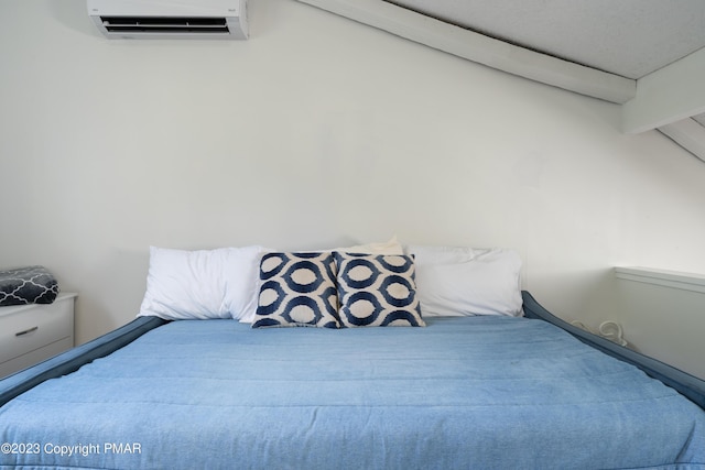 bedroom featuring an AC wall unit and vaulted ceiling