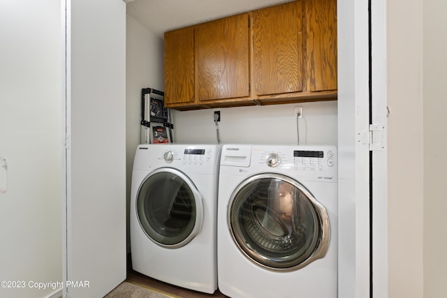 washroom featuring washer and dryer and cabinet space