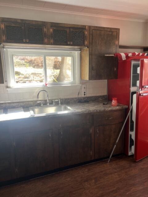 kitchen with dark wood finished floors, decorative backsplash, plenty of natural light, and a sink