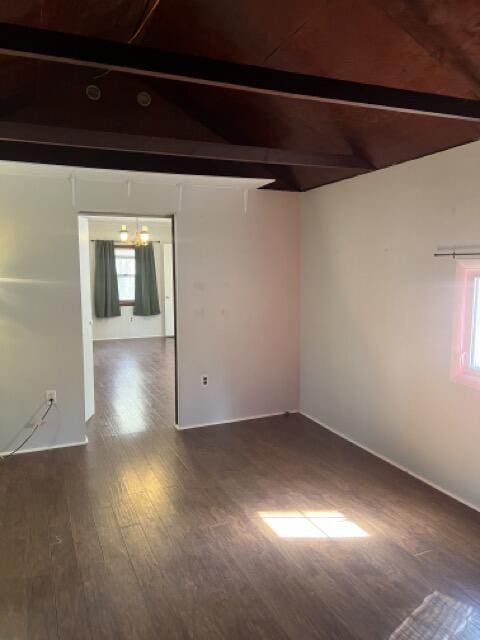 unfurnished room with vaulted ceiling with beams and wood finished floors