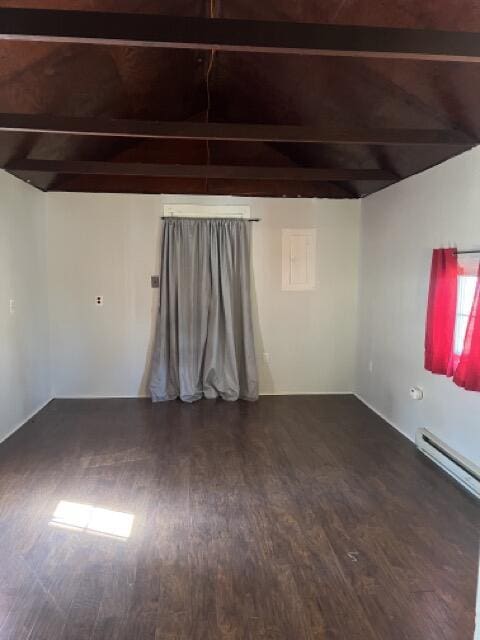 unfurnished room featuring a baseboard heating unit, lofted ceiling with beams, and wood finished floors