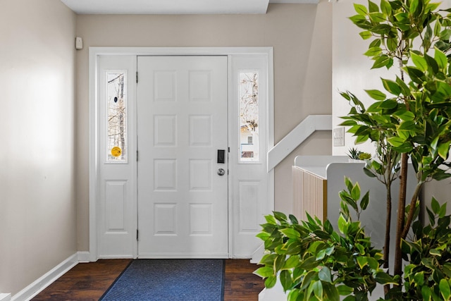 entryway featuring dark wood-type flooring, plenty of natural light, and baseboards