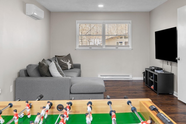 living area with a baseboard radiator, baseboards, wood finished floors, and a wall unit AC