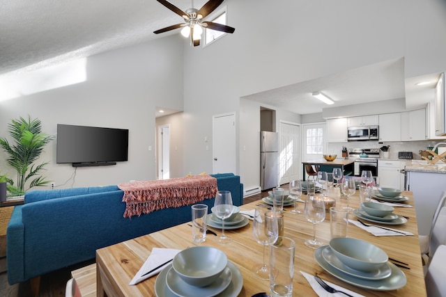 dining area with high vaulted ceiling and ceiling fan