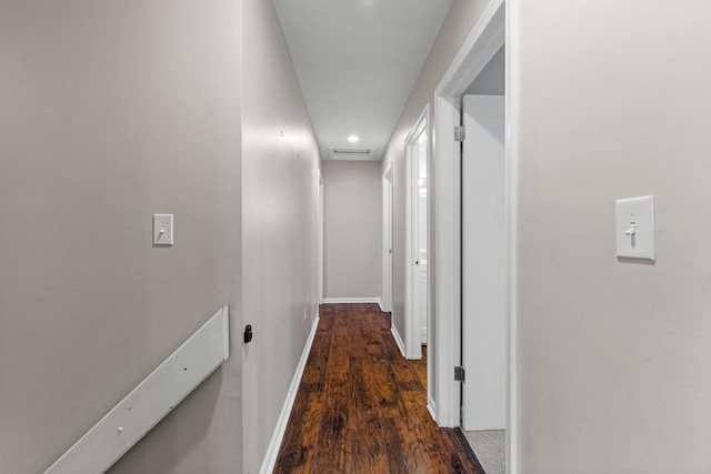 hall with visible vents, attic access, baseboards, and wood finished floors