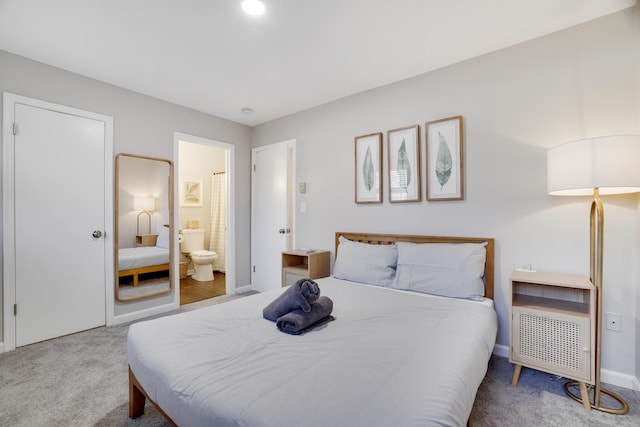 bedroom with connected bathroom, baseboards, and carpet floors