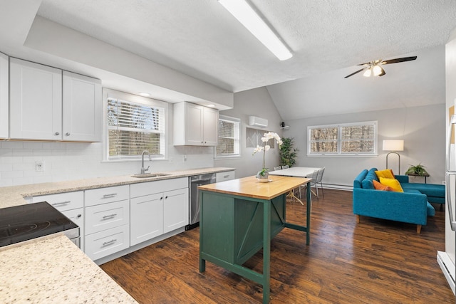 kitchen with vaulted ceiling, dark wood-style flooring, stainless steel dishwasher, white cabinets, and a sink