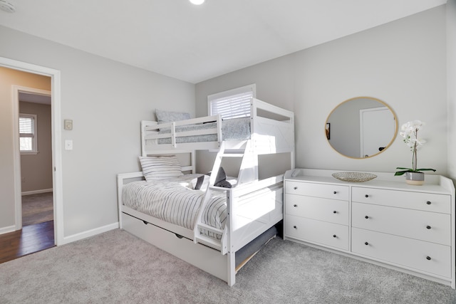 bedroom with baseboards and light carpet