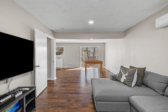 living area featuring an AC wall unit, a baseboard heating unit, a textured ceiling, wood finished floors, and baseboards