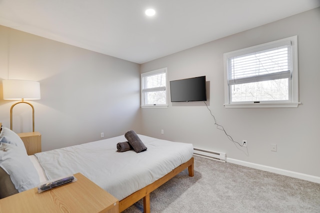 carpeted bedroom with a baseboard heating unit and baseboards