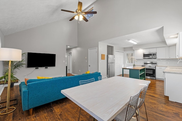 dining space with dark wood-style floors, lofted ceiling, a textured ceiling, and ceiling fan