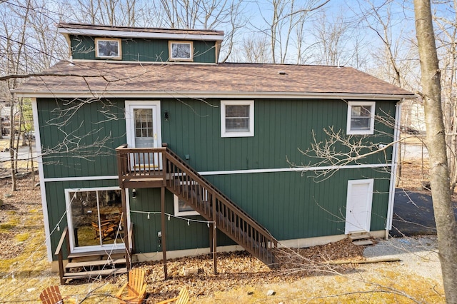 view of front of house featuring stairs and a shingled roof