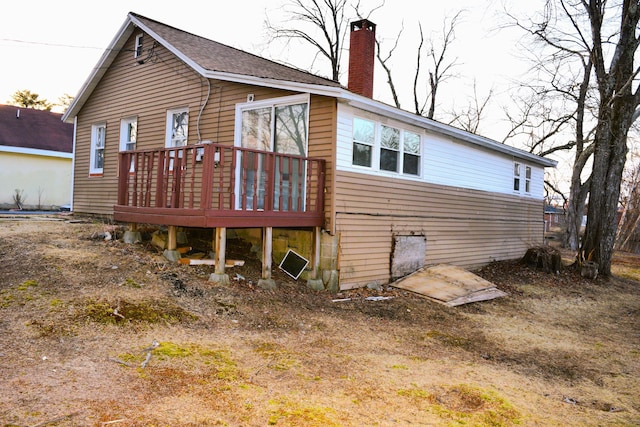 back of property with a wooden deck and a chimney