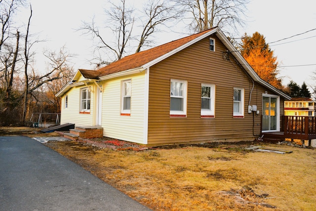 view of side of home with entry steps and a yard