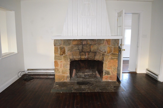 interior details featuring a baseboard heating unit, wood finished floors, a fireplace, baseboards, and baseboard heating