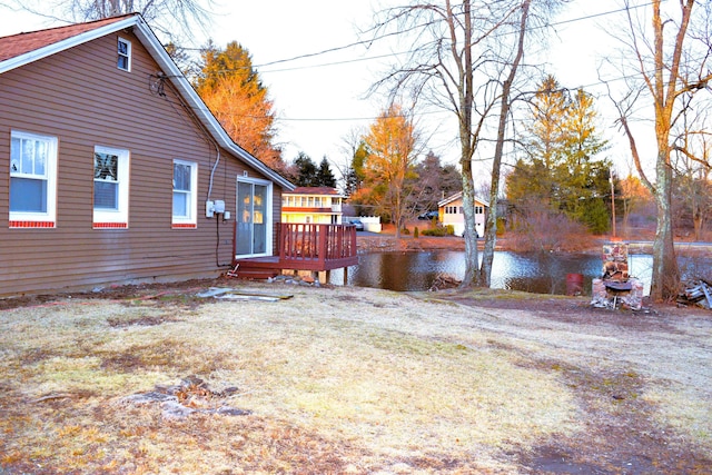 view of yard with a deck with water view