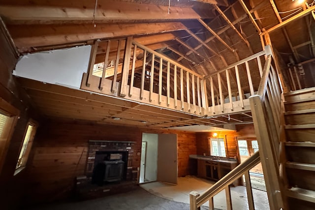 9416 Juniper Dr, Tobyhanna, PA 18466 - staircase featuring a wood stove, lofted ceiling, and wood walls