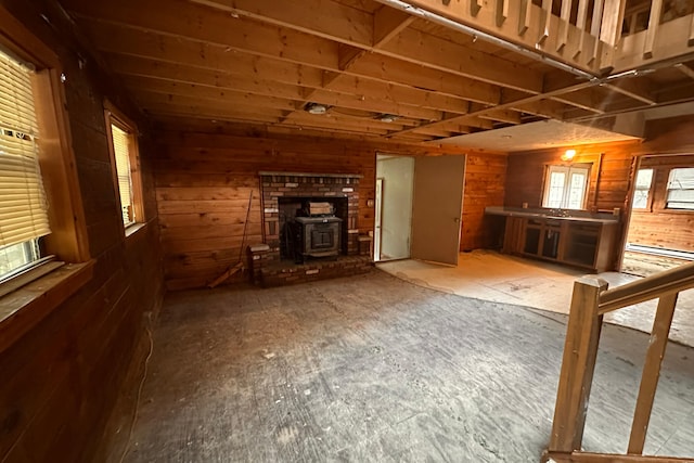 9416 Juniper Dr, Tobyhanna, PA 18466 - unfurnished living room with wooden walls, a wood stove, and a baseboard radiator