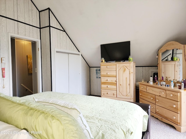 bedroom featuring lofted ceiling, light carpet, and a closet