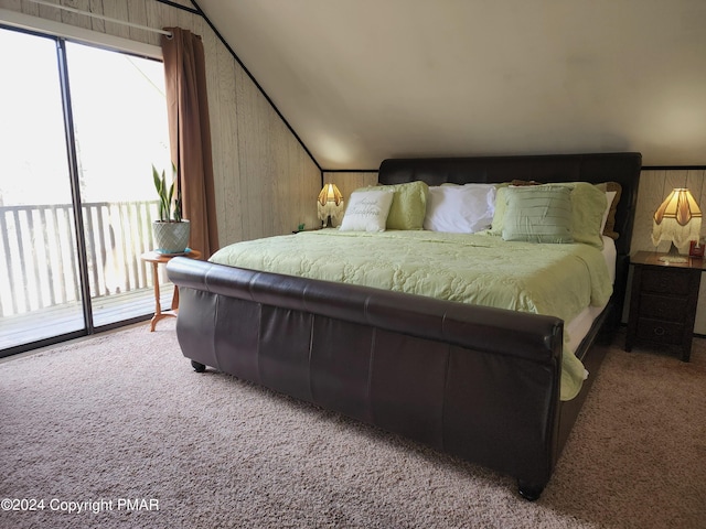 carpeted bedroom with lofted ceiling, wood walls, and access to outside