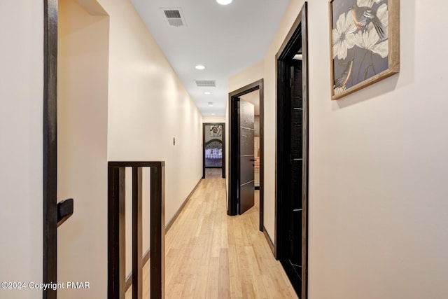 hallway with light wood-style floors, baseboards, visible vents, and recessed lighting