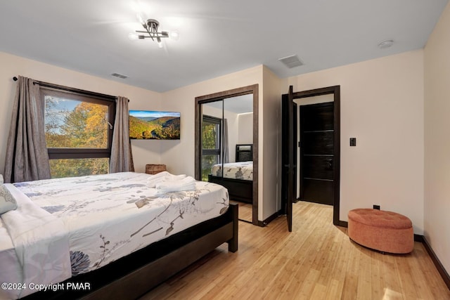 bedroom featuring baseboards, a closet, visible vents, and light wood-style floors