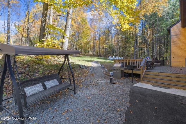 view of yard with a wooded view and a wooden deck