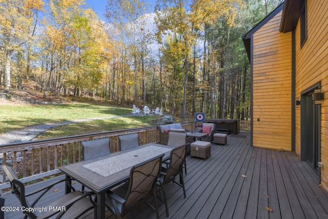 deck featuring outdoor dining area and a yard