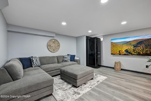 living room with recessed lighting, light wood-style flooring, and baseboards