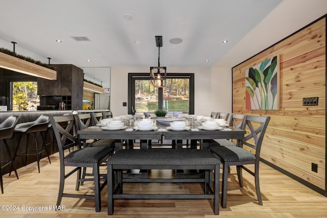 dining room featuring recessed lighting, visible vents, wood walls, and light wood finished floors