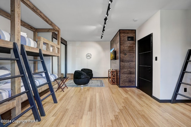 interior space featuring baseboards, expansive windows, wood finished floors, and track lighting