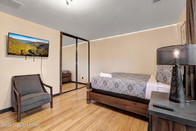 bedroom featuring light wood-type flooring, visible vents, and baseboards