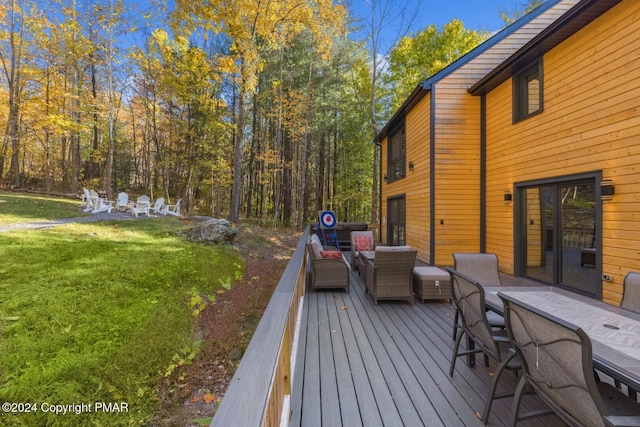 wooden deck featuring outdoor lounge area and a lawn