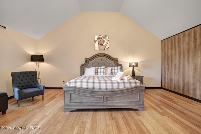 bedroom with lofted ceiling, baseboards, and wood finished floors