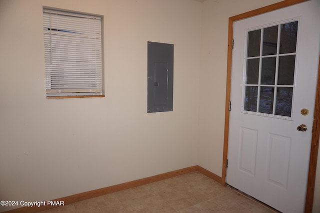 doorway with light floors, electric panel, and baseboards